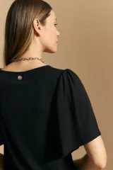 Remera de rib color beige, con cuello redondo y mangas cortas amplias con leve frunce en los hombros. Confeccionada en tejido elastizado de textura acanalada.