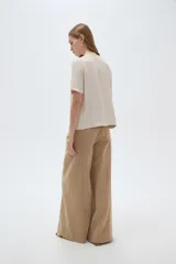 Blusa marrón de manga corta con cuello en V y cierre frontal cruzado con tres botones.