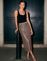 Falda midi de lentejuelas, con pretina elastizada y tajo en el ruedo.