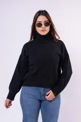 Poleron de cuello alto, manga larga y corte relajado, confeccionado en tejido de punto suave y abrigado.