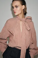 Camisa de algodón con estampado de rayas verticales, cuello subido con lazada frontal, manga larga abullonada y puños ajustados.