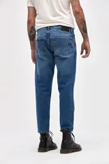 Jean de corte recto y tiro medio, en color azul clásico con acabado lavado. Presenta cierre de cremallera y botón metálico, con diseño de cinco bolsillos.