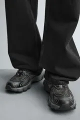 Zapatilla deportiva tipo running color blanco hueso con detalles en azul marino y amarillo flúor.