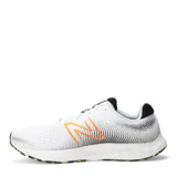 Championes de running New Balance modelo 520, color blanco con detalles en negro y naranja. Presentan capellada de malla transpirable, logo lateral en naranja y entresuela con diseño texturizado en degradado amarillo.