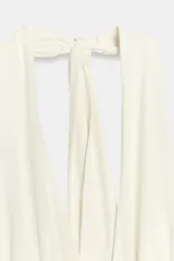 Vestido largo color blanco con cuello halter y escote en pico pronunciado. Detalle de frunces, forro interior y abertura en la espalda.