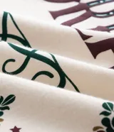 Remera de algodón color beige con cuello redondo, mangas cortas y corte holgado. Presenta un estampado frontal con la frase 'Cosmic Dream' rodeada por un diseño de estilo bandana.