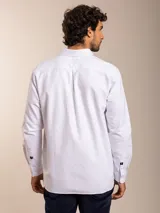 Camisa blanca de corte clásico con cuello abotonado, manga larga y bolsillo en el pecho.
