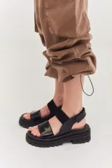 Sandalias de plataforma con suela track, combinando cuero marrón, gamuza y detalles en textura reptil. Cuentan con tira ajustable en el tobillo y diseño ergonómico.