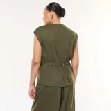 Chaleco de traje color verde oliva, con escote en V, cierre frontal con botones y bolsillos laterales con solapa.