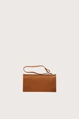 Bolsa tipo tote de textura tejida en color natural, con detalles de ribetes, asas y cordones decorativos en cuero sintético color suela.