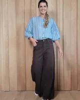 Pantalón de jean color beige, de corte recto y tiro alto, con ruedo deshilachado y cierre frontal con botón y cremallera.