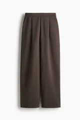 Pantalón de punto de tiro alto y corte holgado color marrón, con piernas amplias, pinzas en la cintura y bolsillos al bies.