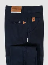 Pantalón de vestir negro, de corte recto, con bolsillos laterales y traseros. Se ajusta a la cintura con cinturón de cuero marrón.