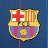 Camiseta de fútbol azul con rayas verticales rojas, escudo del FC Barcelona en el pecho y la palabra "Barça" en el lado izquierdo.