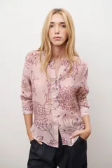 Camisa de manga larga con cuello mao y cierre frontal de botones, confeccionada en tela ligera con estampado floral en tonos rosados y violetas.