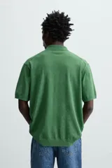 Polo de punto tejido de algodón con efecto lavado, color amarillo pálido. Presenta un calce regular fit, cuello solapa con cierre frontal de tres botones y manga corta.