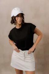 Sweater de punto color blanco, de corte relajado, con cuello redondo, manga corta japonesa de hombro caído y pretina ancha en la cintura.