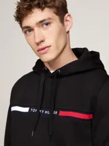 Buzo con capucha y cordón ajustable Tommy Hilfiger de color negro, con bolsillo tipo canguro y detalle de franja horizontal tricolor en el pecho con el nombre de la marca.