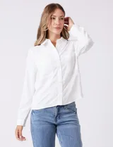 Camisa blanca de crepe, marca Ninety, con cuello solapa, cierre frontal de botones y dos bolsillos aplicados en el pecho.