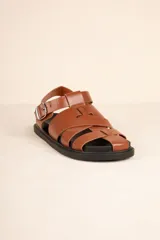 Sandalias bajas tipo gladiador, color negro, con tiras entrelazadas y hebilla metálica ajustable.