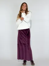 Pollera larga de terciopelo color borgoña, con corte recto y paneles verticales.