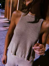 Blusa de punto color beige con lurex, modelo halter y diseño acanalado.