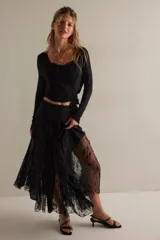 Falda larga negra de encaje floral con transparencias y caída amplia.