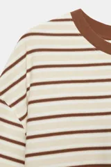 Camiseta de algodón a rayas horizontales en tonos marrones y beige, de corte regular fit, cuello redondo a contraste de color marrón oscuro y mangas largas por debajo del codo. Presenta diseño de bajo asimétrico.