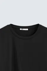 Camiseta de corte ajustado confeccionada en tejido de algodón con elasticidad, cuello redondo y manga corta.