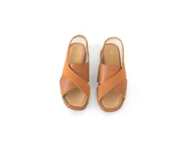 Sandalias Tami de cuero color caramelo, con tiras cruzadas en el empeine, talón con elástico y plataforma baja.