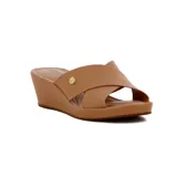 Sandalia tipo mule de mujer con plataforma de cuña en color camel. Presenta tiras anchas cruzadas sobre el empeine y un pequeño aplique metálico circular con logo en uno de los laterales.