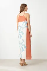 Vestido largo con estampado floral en tonos celeste y blanco, con paneles laterales color durazno. Diseño con breteles finos y corte recto.