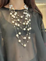 Collar de varias vueltas compuesto por cadenas finas doradas intercaladas con perlas de distintos tamaños. Cuenta con cierre de mosquetón y cadena de alargue.