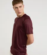 Remera deportiva de manga corta y cuello redondo, color celeste, con tecnología dry y detalles reflectantes en los hombros.