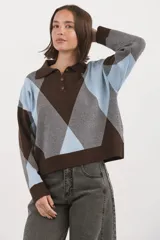 Sweater de tejido de punto con diseño de rombos en tonos marrón, celeste y gris. Presenta cuello polo con cierre frontal de tres botones, mangas largas y puños acanalados.