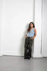 Chaleco de jean en tono azul claro, con escote en V, cierre frontal con botones y diseño entallado.