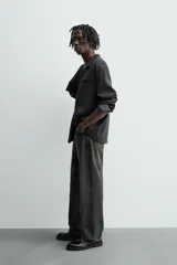 Camisa de manga larga color negro, confeccionada en tejido fluido con mezcla de viscosa. Presenta cuello bowling, bolsillo de vivo en el pecho y efecto lavado.