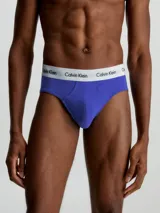 Pack de tres slips de algodón elástico color azul con cintura elástica blanca con logo de Calvin Klein. Corte hip brief.