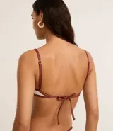 Top de bikini tipo remera confeccionado en microfibra texturizada color blanco con tirantes finos marrones y adorno de cuentas de madera en el centro del busto. Tiene vieses contrastantes y copas removibles.