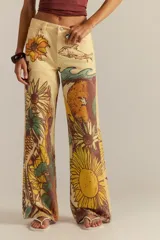 Pantalón de jean recto tiro medio color amarillo, con estampado artístico que incluye girasoles, peces y olas.