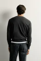 Jersey regular fit de punto ligero color gris oscuro, tejido en hilatura de lana con cuello en V, manga larga y acabados en rib.