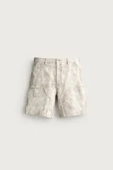 Bermuda relaxed fit color marrón con efecto lavado, cinco bolsillos, bolsillos frontales de carpintero y cierre frontal con cremallera y botón.