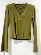 Remera de manga larga color verde oliva, con escote en V profundo y mangas estilo Oxford. Presenta costuras verticales decorativas en el frente y está confeccionada en tela acanalada elastizada.