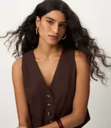 Chaleco femenino confeccionado en viscolino celeste, con escote en v, cierre por botones contrastantes y bolsillos delanteros.