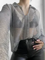 Blusa plateada traslúcida con cuello camisero y mangas largas.