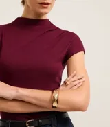 Blusa Cortelle de viscosa color bordó, con cuello alto, manga corta y textura acanalada, de diseño ajustado al cuerpo y terminación sin costuras.