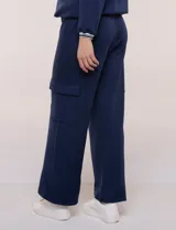 Pantalón jogger azul marino de corte recto y ancho, confeccionado en modal. Presenta pretina elastizada, bolsillos tipo cargo en los laterales y costuras verticales decorativas.