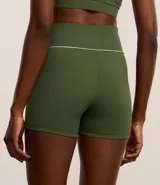 Bermuda deportiva de microfibra acanalada color verde militar, corte ajustado y cintura alta con friso contrastante blanco.