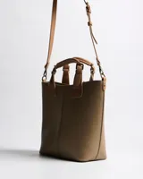 Cartera tipo tote XL de símil cuero con textura granulada en color verde, con dos asas de mano y correa bandolera regulable y desmontable en tono suela. Cuenta con cierre superior, costura central decorativa y parche frontal con logo en relieve.