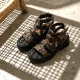 Sandalias de cuero color marrón texturado, con diseño de tiras estilo gladiador, suela flatform track de goma y hebillas metálicas de ajuste.